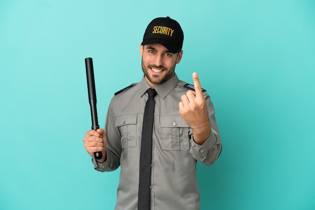 Young security man isolated on blue background doing coming gesture