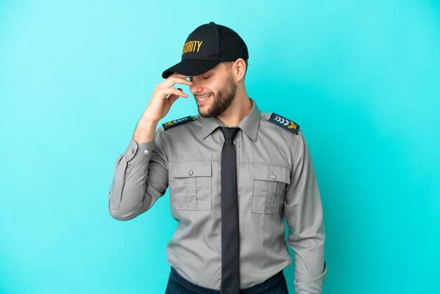 Young security man isolated on blue background laughing