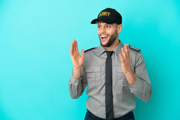 Young security man isolated on blue background with surprise facial expression