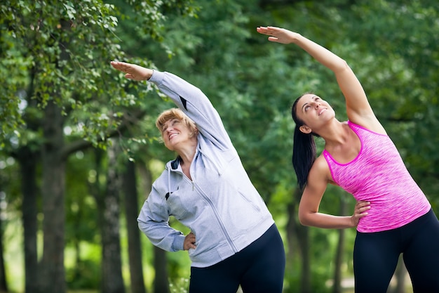 Giovane e donna senior che fa gli sport nel parco