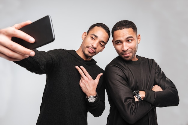 Young serious african men make a selfie.