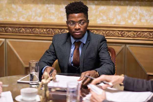 Young serious businessman in eyeglasses and elegant suit