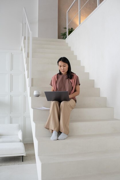 Young serious businesswoman with laptop concentrating on network