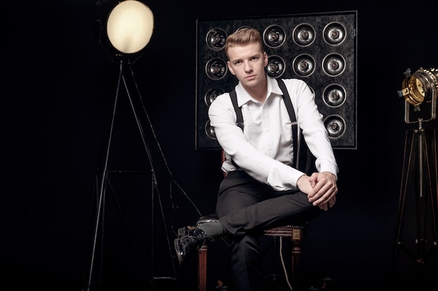 Young serious man on chair, close-up portrait, fashion model