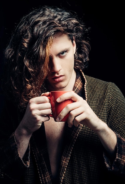 Photo young serious man serious human with cup in hands copy space isolated on black studio background