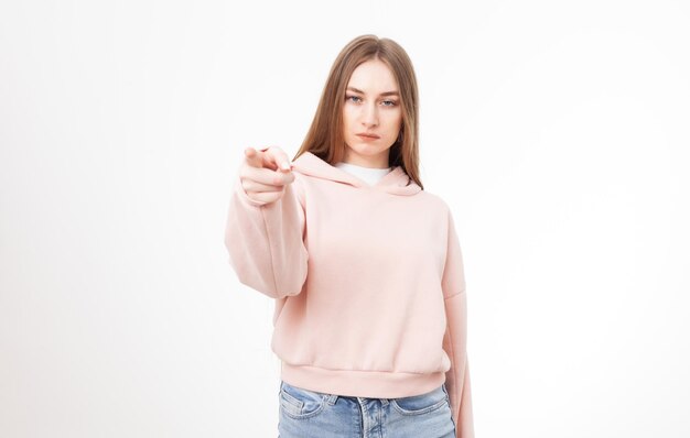 Young serious woman showing index finger at you isolated on white background