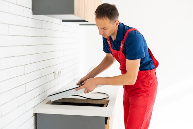 Young service contractor assembling kitchen furniture