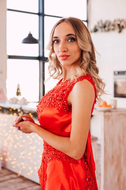 Young sexy blonde woman posing in apartment with new year decor