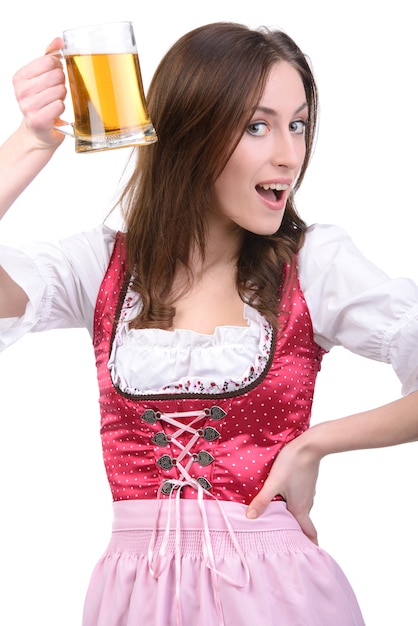 Foto giovane ragazza sexy in abito nazionale con un bicchiere di birra.