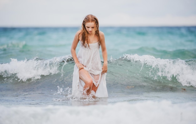 파도 바다 여름 해변에서 젊은 섹시 한 여자 열 대 해변 휴가에 흰 드레스에 관능적인 여자 소녀