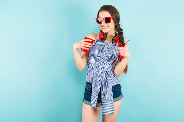 Young sexy woman with headphones and cup