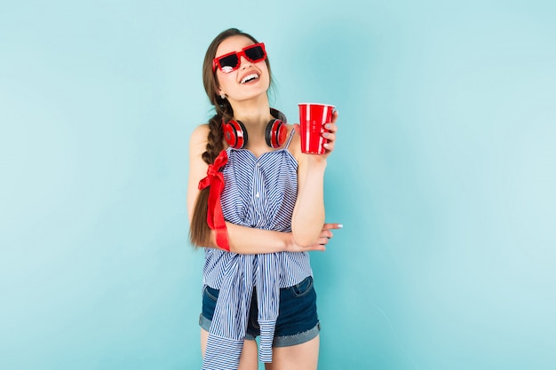 Young sexy woman with headphones and cup