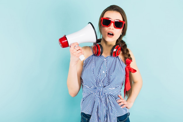 Young sexy woman with headphones and loudspeaker