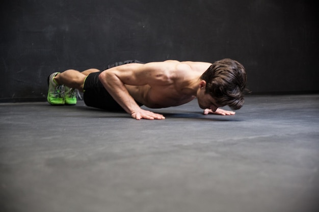 Photo young shirtless man exercising on floor