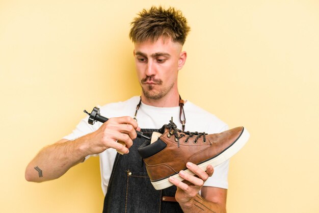 Young shoemarket man isolated on yellow background