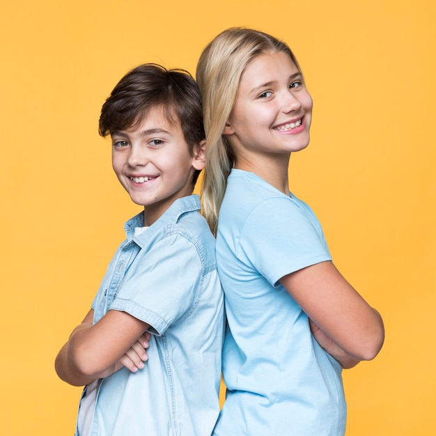 Photo young siblings standing back to back