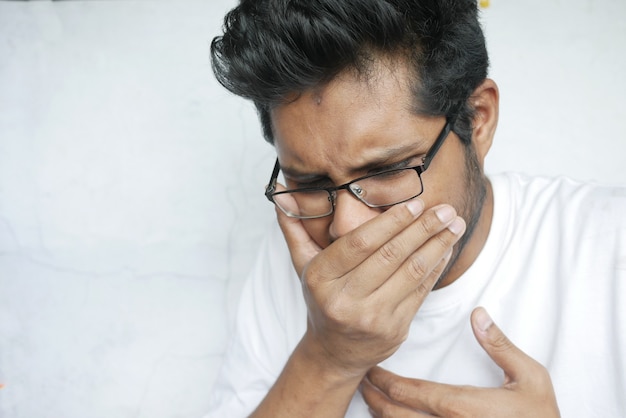 young sick man coughing and sneezes