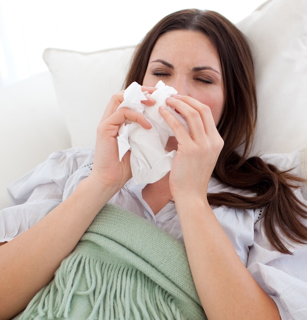 Young sick woman lying on the sofa 