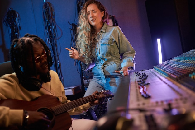 Foto giovane cantante che canta una canzone in studio