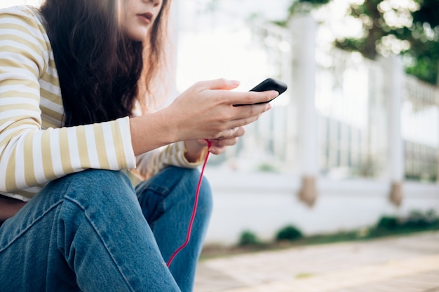 Young skateboarder looking at mobile phone 