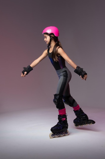 young skater athlete with pink helmet and protective gear for competition studio photo