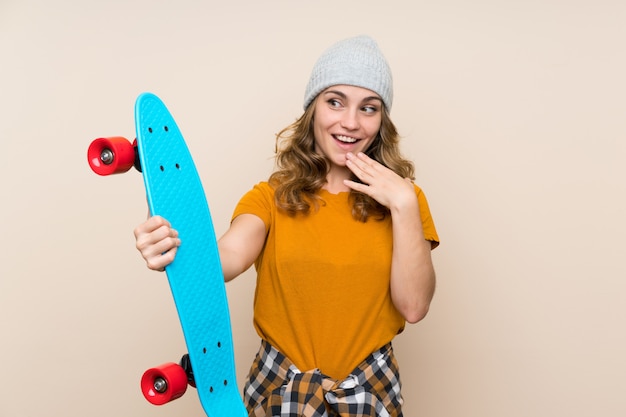 Young skater blonde girl over isolated wall with surprise and shocked facial expression