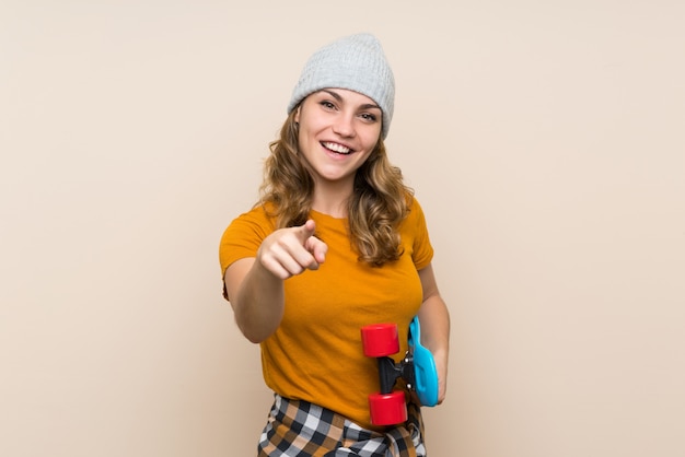 Young skater blonde girl over isolated wall