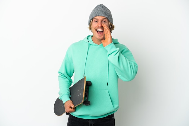 Young skater blonde man isolated on white background shouting with mouth wide open