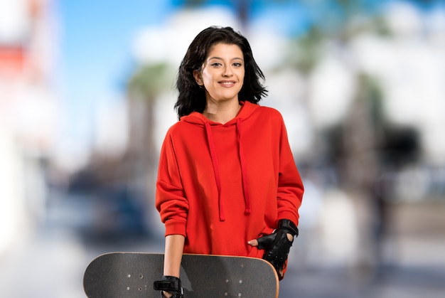 赤いスウェットシャツの若いスケーター女性