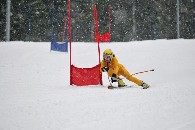 молодой лыжник быстро мчится вниз по зимней снежной сцене