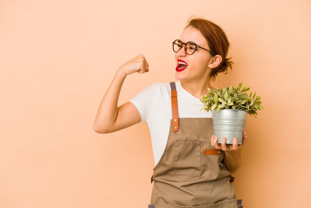 Photo young skinny arab gardener woman raising fist after a victory, winner concept.