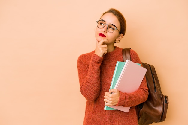 疑わしいと懐疑的な表現で横向きに見える若い細いアラブの学生女性