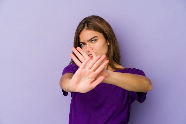 Giovane adolescente magro ragazza caucasica su viola facendo un gesto di diniego