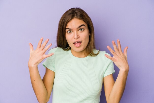 Young skinny caucasian girl teenager on purple showing number ten with hands.