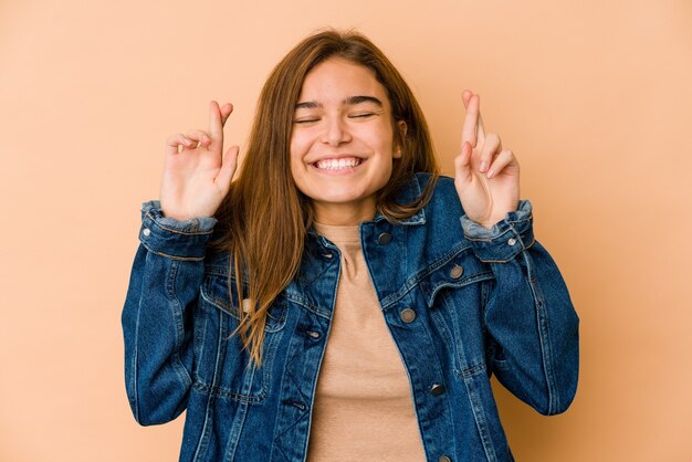 Young skinny caucasian teenager girl crossing fingers for having luck