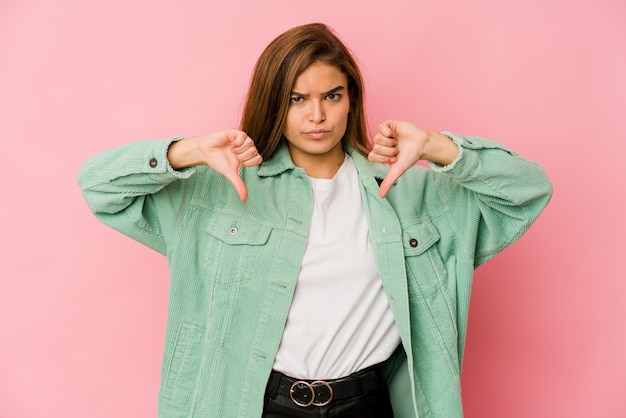 Young skinny caucasian teenager girl showing a dislike gesture, thumbs down. Disagreement concept.