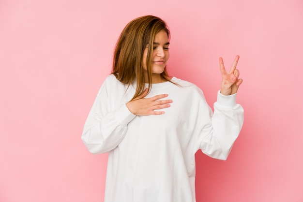 Young skinny caucasian teenager girl taking an oath, putting hand on chest.