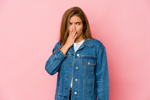 Young skinny caucasian teenager girl yawning showing a tired gesture covering mouth with hand.