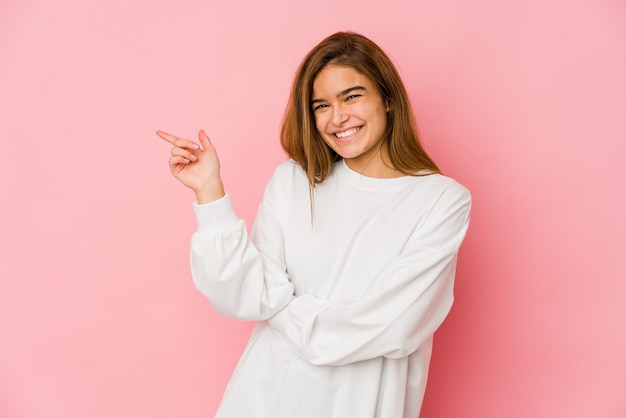 Young skinny teenager girl smiling cheerfully pointing with forefinger away