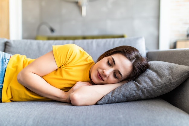 Young sleeping woman is lying on a pillow on a couch