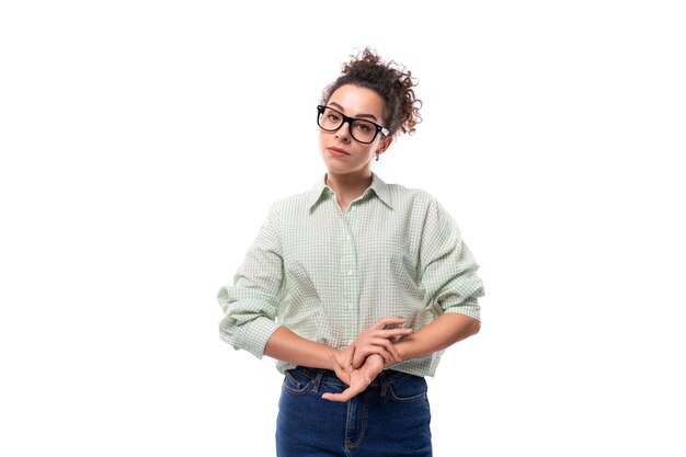 Young slender brunette assistant woman in glasses dressed in a shirt and jeans