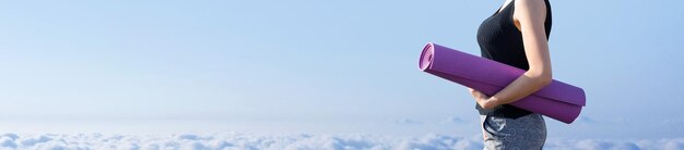 A young slim athletic girl in sportswear performs a set of exercises Fitness and healthy lifestyle against the background of clouds sky