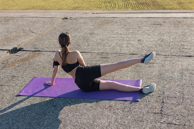 A young slim athletic girl in sportswear performs a set of exercises Fitness and healthy lifestyle