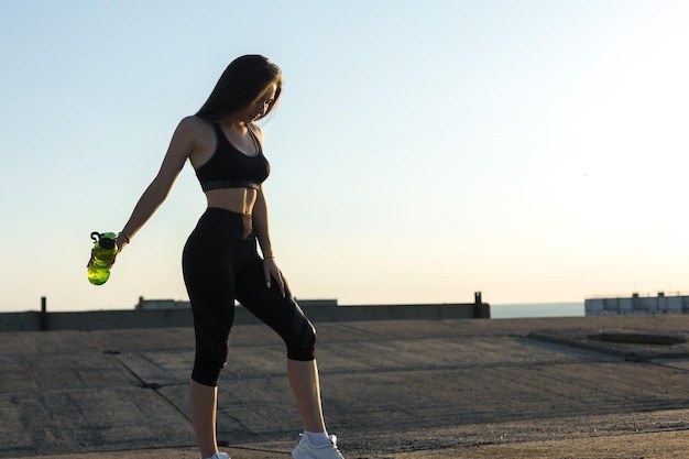 A young slim athletic girl in sportswear performs a set of exercises