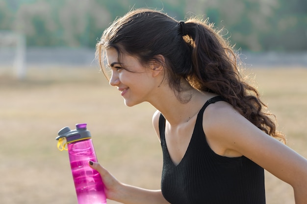 A young slim athletic girl in sportswear with snakeskin prints performs a set of exercises. Fitness and healthy lifestyle.