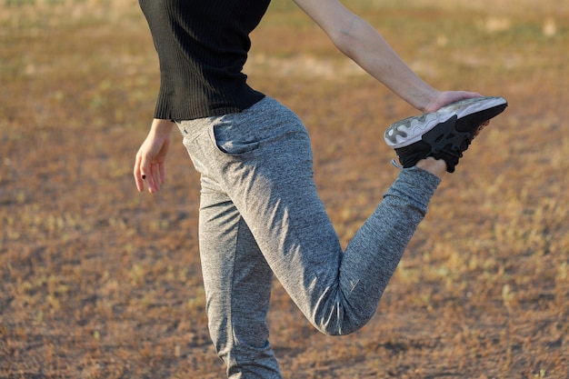 A young slim athletic girl in sportswear with snakeskin prints performs a set of exercises