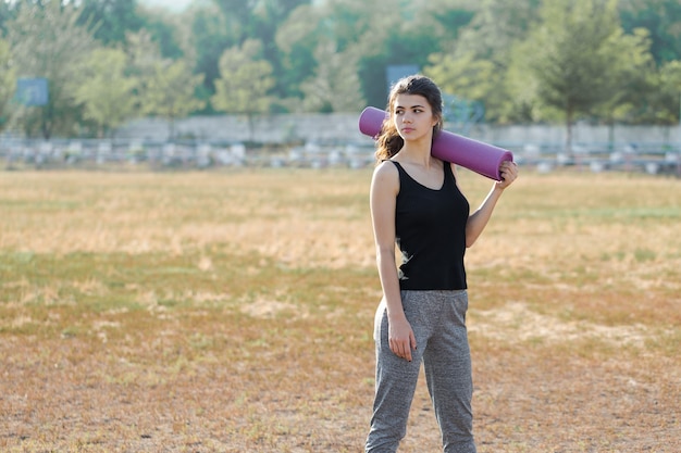 A young slim athletic girl in sportswear with snakeskin prints performs a set of exercises