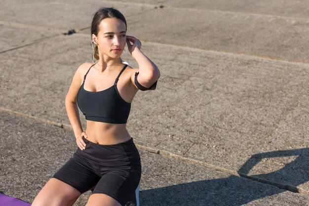 A young slim athletic girl in sportswear with snakeskin prints performs a set of exercises