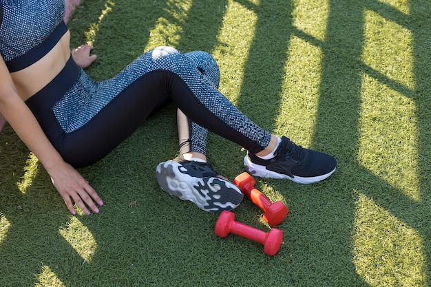 Молодая стройная спортивная девушка в спортивной одежде со змеиным принтом выполняет комплекс упражнений