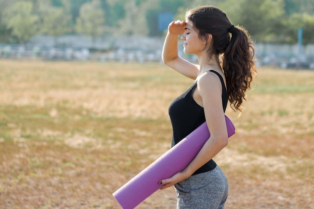 A young slim athletic girl in sportswear with snakeskin prints performs a set of exercises